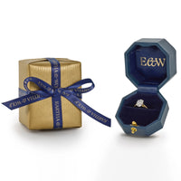 Oval 1.20ct diamond solitaire engagement ring in jewellery box placed next to a gift wrapped box with blue Eartha & Wolf branded ribbon