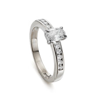 Modern 0.65ct oval diamond engagement ring with channel set diamond band in white gold