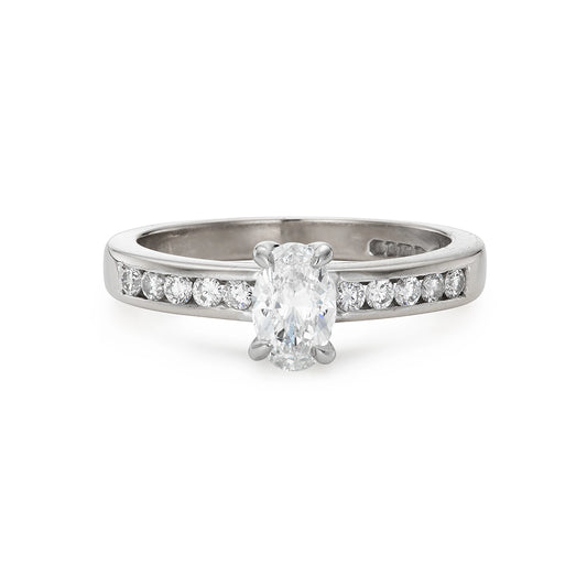 Modern 0.65ct oval diamond engagement ring with channel set diamond band in white gold