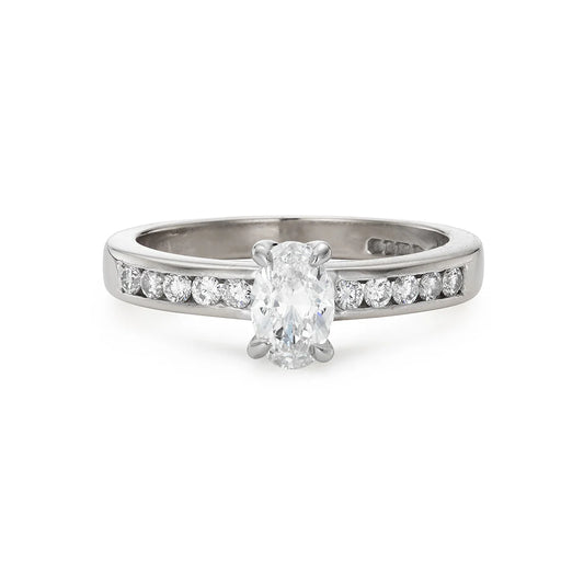 Modern 0.65ct oval diamond engagement ring with channel set diamond band in white gold